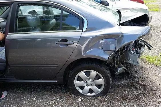 Auto gris chocado en el sector trasero