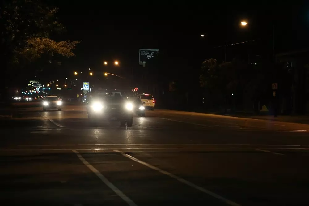 Auto con la luces encendidas siguiendo los Consejos para conducir de noche