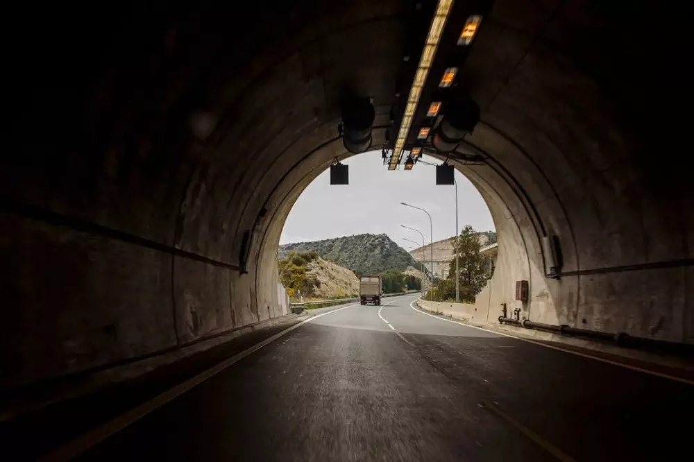 Auto saliendo de un túnel con el sol de frente
