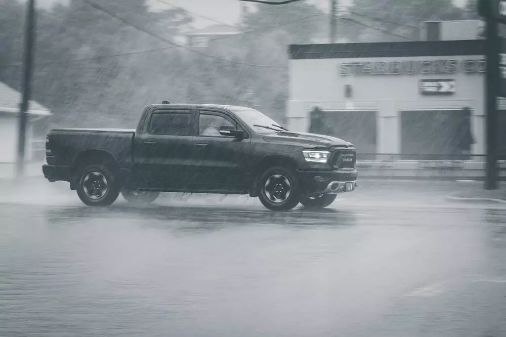Camioneta negra siguiendo los Consejos para Conducir con Lluvia