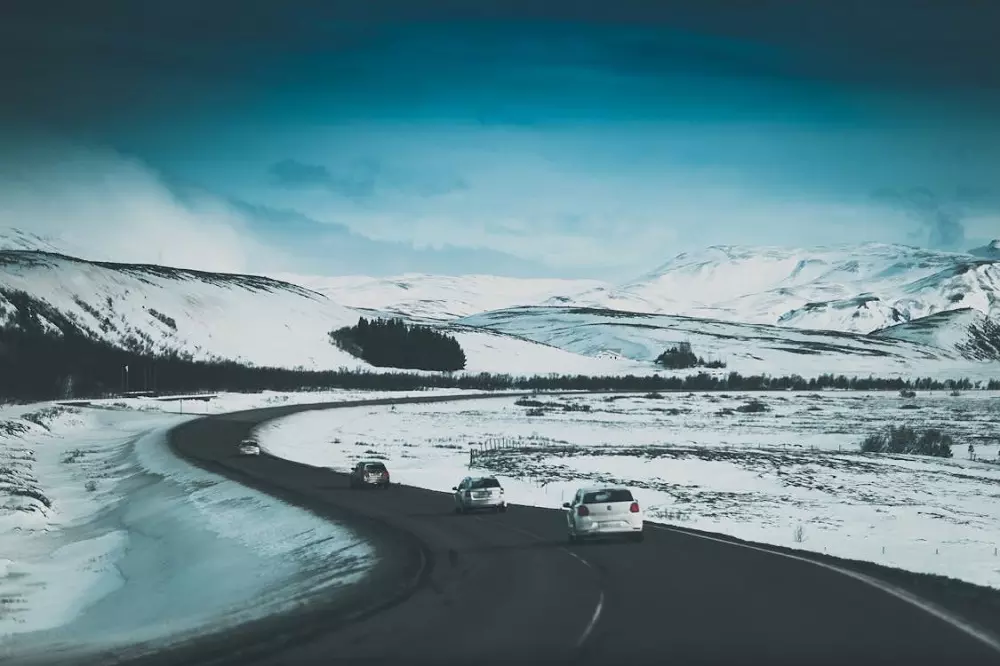 Autos circulando por ruta con los costados nevados
